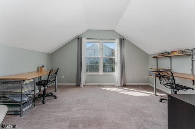 carpeted office featuring lofted ceiling and baseboards