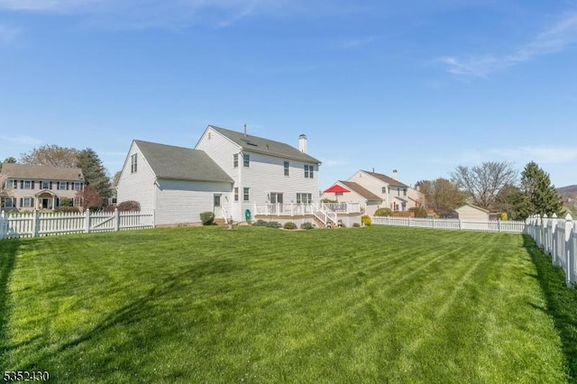 back of house with stairs, a yard, a fenced backyard, and a deck