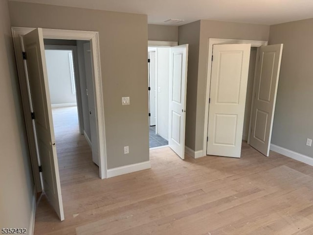unfurnished bedroom featuring baseboards and light wood-type flooring