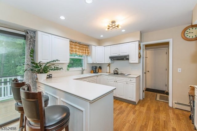 8 Kevin Dr, Mount Olive Twp, NJ 07836 - kitchen featuring a peninsula, under cabinet range hood, white cabinets, light countertops, and recessed lighting