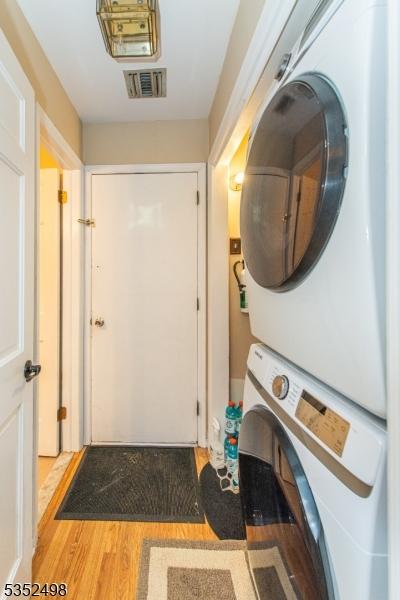 8 Kevin Dr, Mount Olive Twp, NJ 07836 - laundry room with stacked washer / dryer and wood finished floors