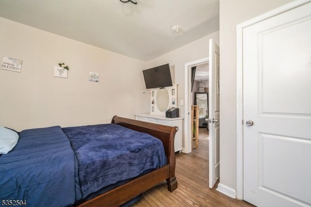 bedroom with wood finished floors and baseboards