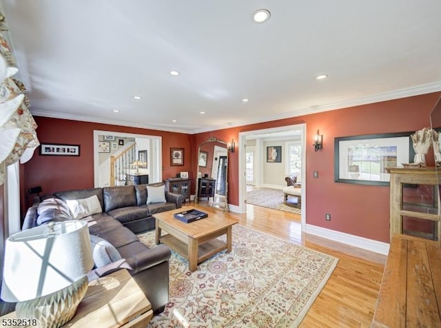 living area featuring arched walkways, light wood-style flooring, recessed lighting, baseboards, and a fireplace
