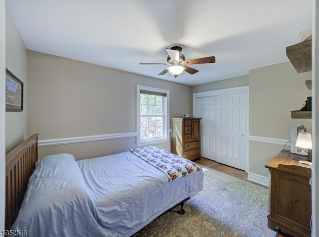 bedroom featuring a closet, wood finished floors, ceiling fan, and baseboards