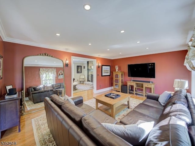 living area featuring light wood-type flooring, recessed lighting, crown molding, baseboards, and arched walkways