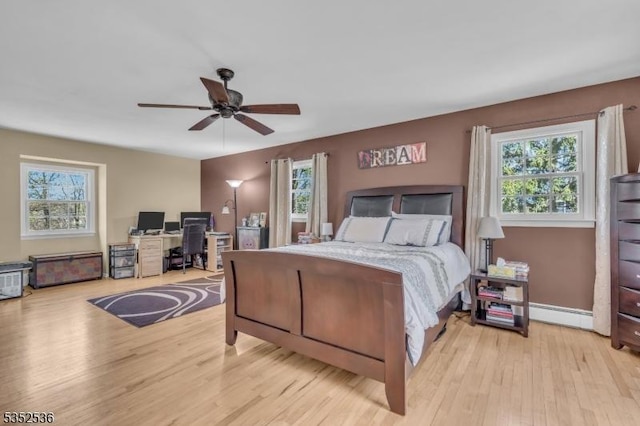 bedroom with ceiling fan, multiple windows, and light wood-type flooring