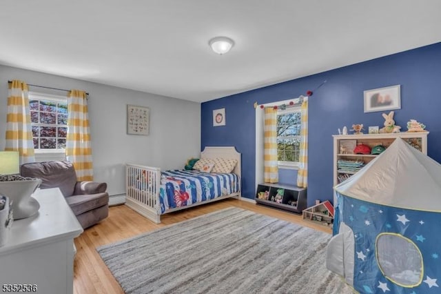 bedroom featuring a baseboard radiator and wood finished floors