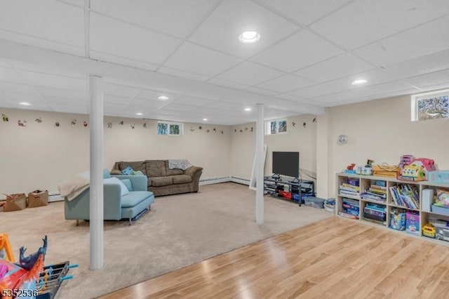 living area with recessed lighting, a paneled ceiling, and wood finished floors