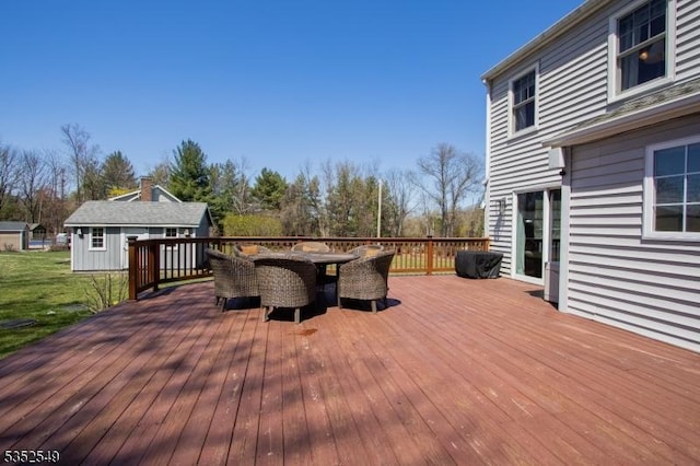 wooden deck with an outdoor structure and outdoor dining area