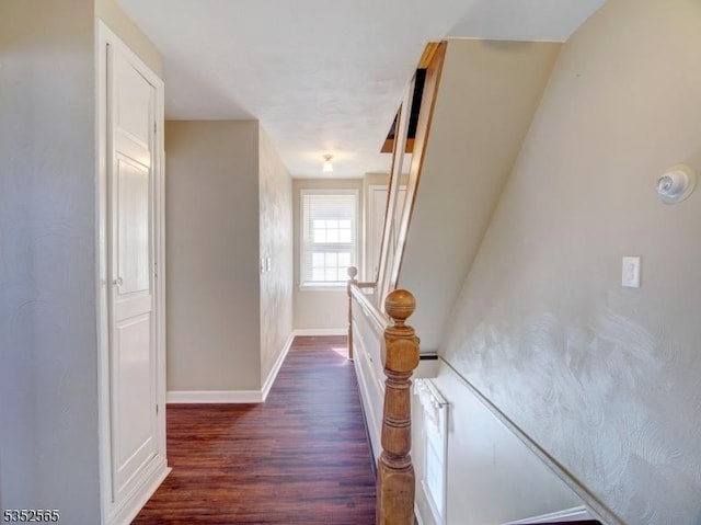 corridor featuring dark wood finished floors and baseboards