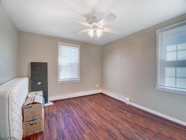 interior space featuring baseboards, wood finished floors, and a ceiling fan