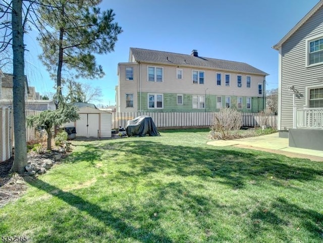 view of yard with an outdoor structure, a storage unit, a patio area, and fence