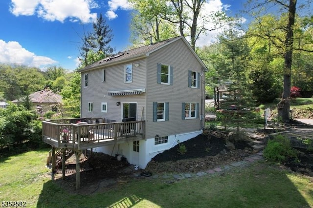 rear view of property featuring a yard and a deck