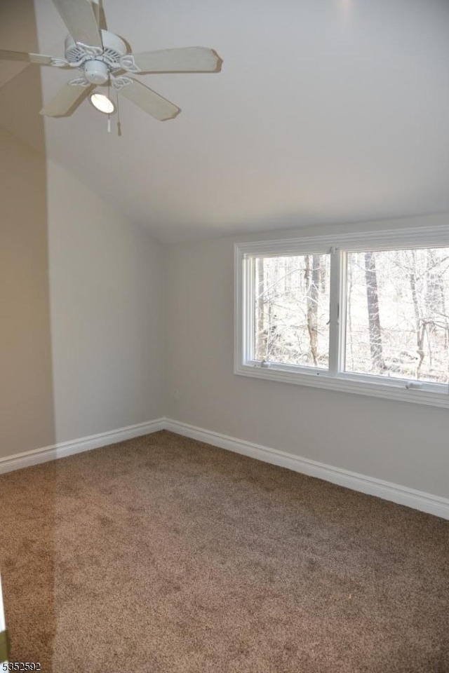 carpeted empty room with baseboards, ceiling fan, and vaulted ceiling