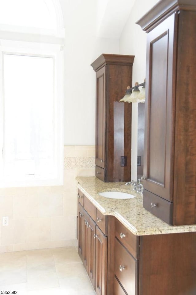 bathroom featuring vanity and tile walls