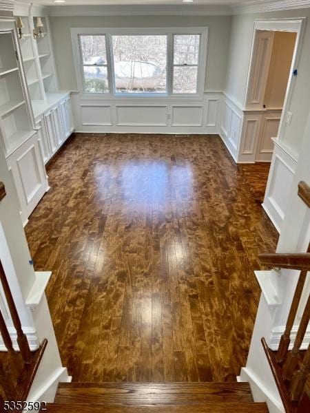 interior space featuring a decorative wall, dark wood-style floors, and stairs
