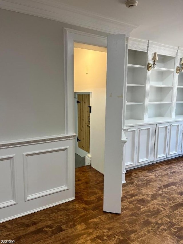 empty room with crown molding and wood finished floors