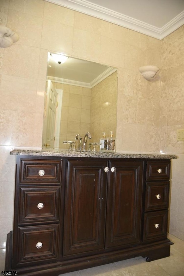 bathroom with crown molding, tile walls, and a sink