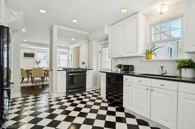 kitchen featuring a sink, dark countertops, black appliances, and a wealth of natural light
