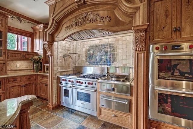 770 Pottersville Rd, Chester Twp, NJ 07931 - kitchen with appliances with stainless steel finishes, a warming drawer, brown cabinetry, stone tile floors, and custom exhaust hood
