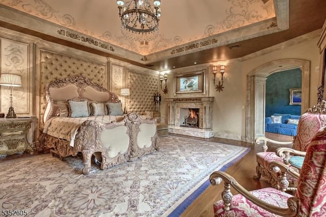 770 Pottersville Rd, Chester Twp, NJ 07931 - bedroom with a fireplace, a chandelier, ornamental molding, arched walkways, and wood finished floors