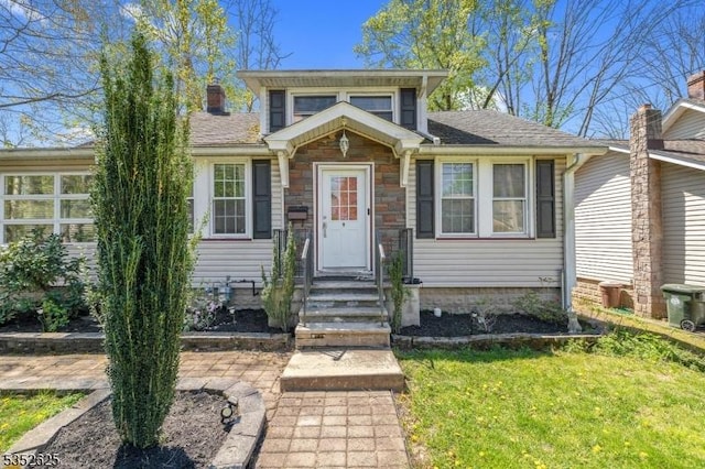 bungalow-style house with a chimney and a front yard