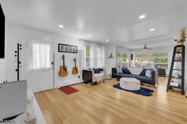 living room with light wood-style floors, a ceiling fan, and recessed lighting