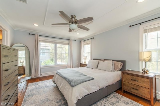 bedroom with crown molding, recessed lighting, wood finished floors, and multiple windows