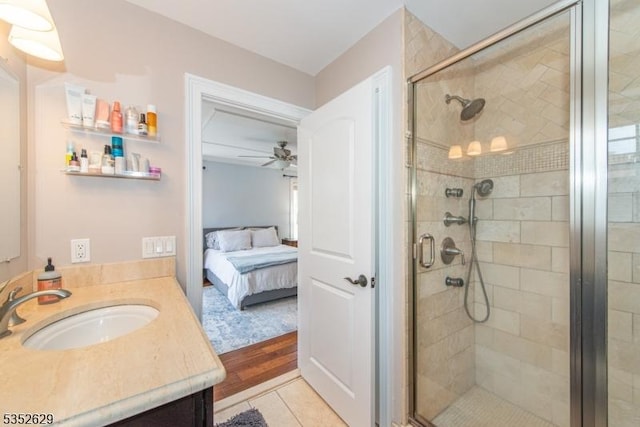 full bathroom featuring vanity, a ceiling fan, a shower stall, and ensuite bath