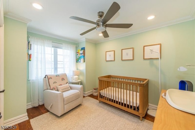 bedroom featuring crown molding, a nursery area, and baseboards