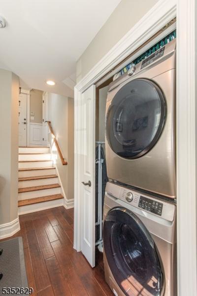 washroom featuring laundry area, stacked washer and dryer, baseboards, dark wood-type flooring, and recessed lighting