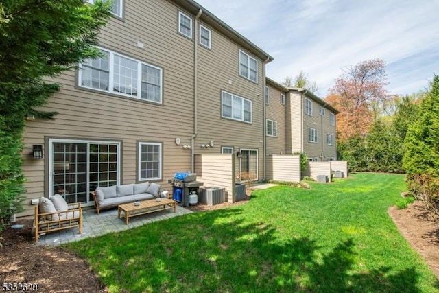 rear view of house with a yard, outdoor lounge area, a patio area, and central air condition unit