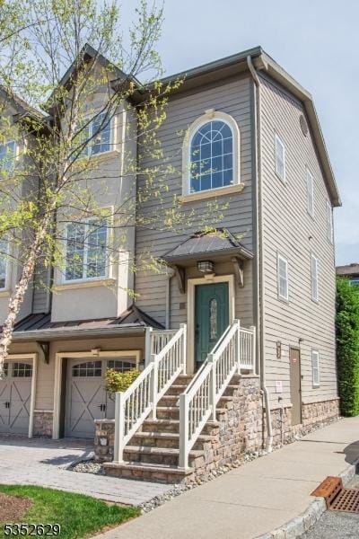 view of front of house with an attached garage and stone siding
