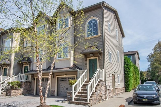 view of property featuring a garage, driveway, and stone siding