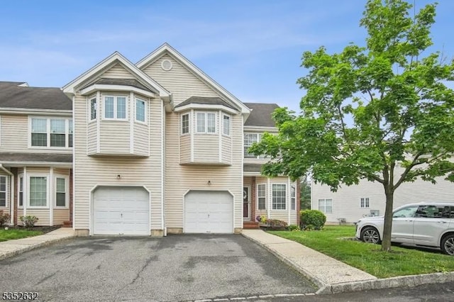 view of property featuring asphalt driveway and an attached garage