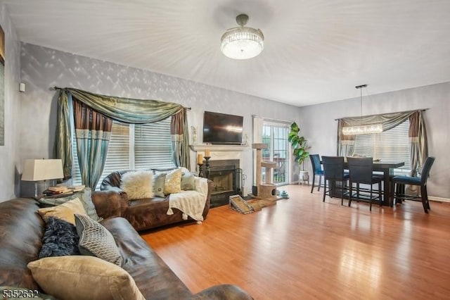 living room with wood finished floors, a fireplace, and a chandelier