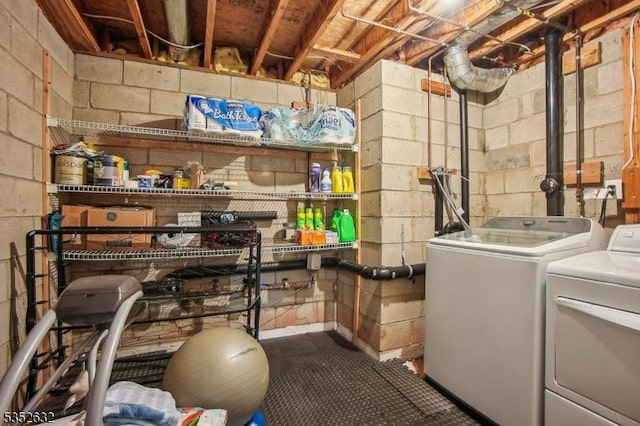 laundry area with separate washer and dryer and concrete block wall