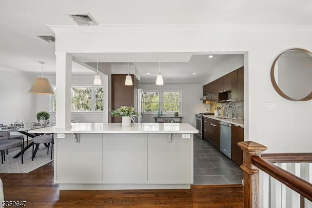 kitchen featuring a sink, light countertops, stainless steel appliances, backsplash, and visible vents