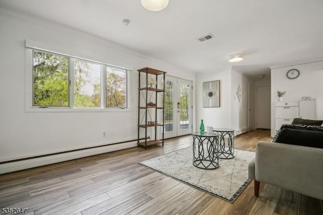 living area with visible vents, a healthy amount of sunlight, and baseboard heating