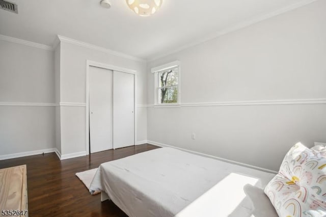 bedroom with crown molding, baseboards, wood finished floors, and visible vents