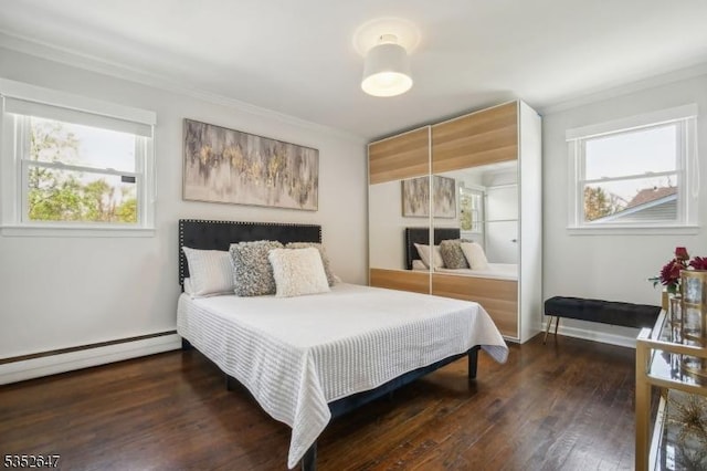 bedroom featuring crown molding, baseboard heating, hardwood / wood-style floors, baseboards, and a closet