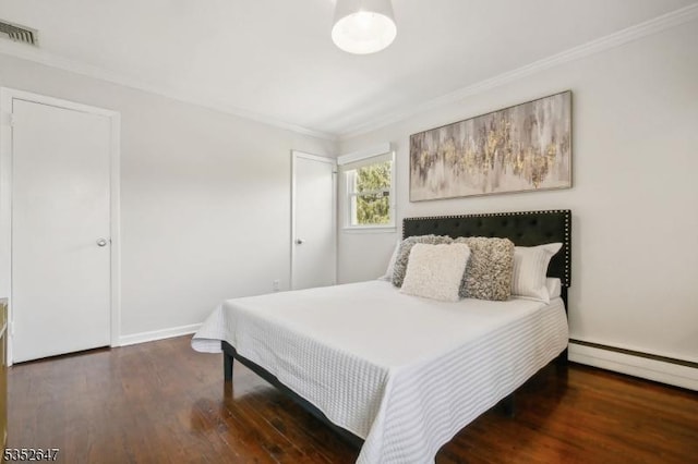 bedroom with visible vents, crown molding, wood finished floors, baseboards, and baseboard heating