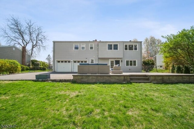 back of house with a garage and a yard