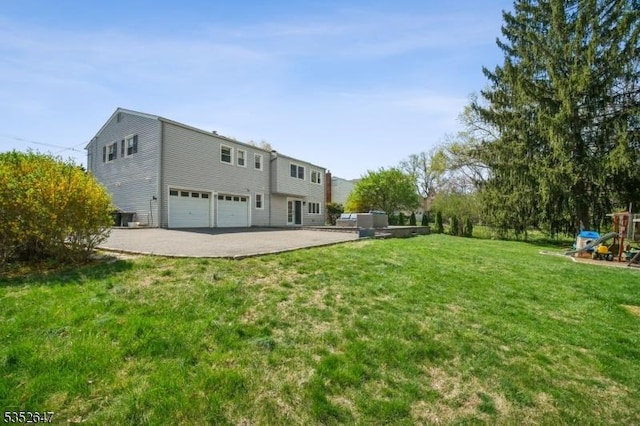 rear view of property with a garage, a lawn, central air condition unit, and concrete driveway