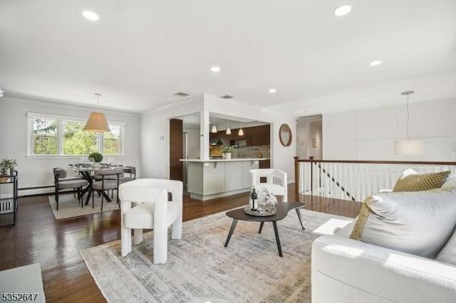 living area featuring recessed lighting, a baseboard heating unit, and wood finished floors
