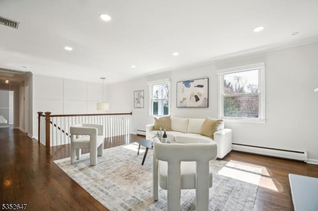 living room featuring visible vents, a baseboard radiator, wood finished floors, and ornamental molding
