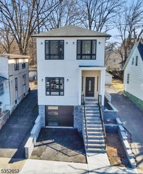 784 Valley St, Union Twp, NJ 07088 - view of front facade with roof with shingles, stairway, and aphalt driveway