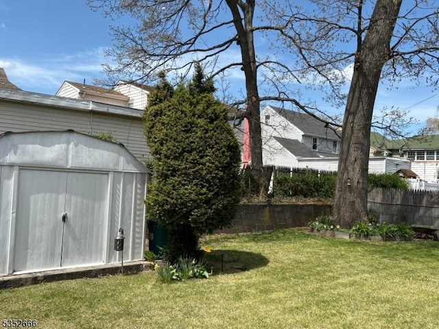 view of yard featuring fence, an outbuilding, and a storage shed