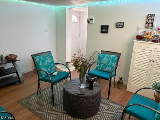 living area featuring baseboards and wood finished floors