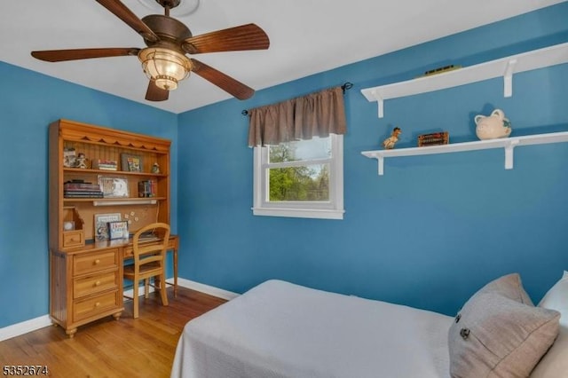 bedroom featuring wood finished floors, a ceiling fan, and baseboards